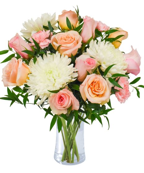 soft peach roses, pink carnations, and white mums in a clear glass vase